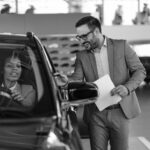 Sales person speaking to potential client. Learn how auto dealers can thrive.