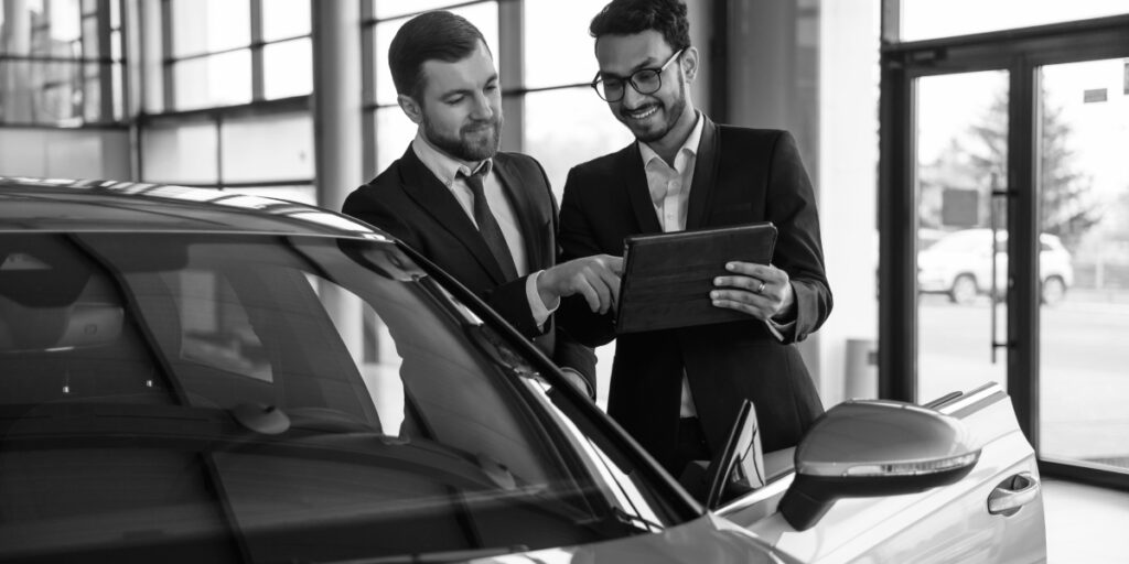 Salesperson and finance manager reviewing CUDL SmartFund on a tablet.